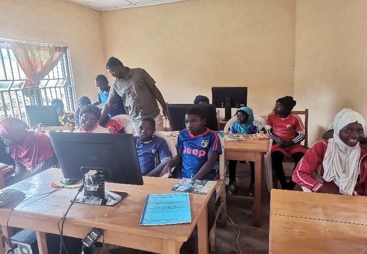 Women and youths learning basic computer skills