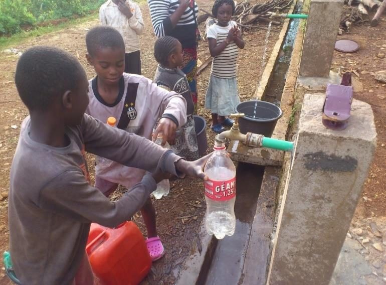 A child fetching clean water from a community tap